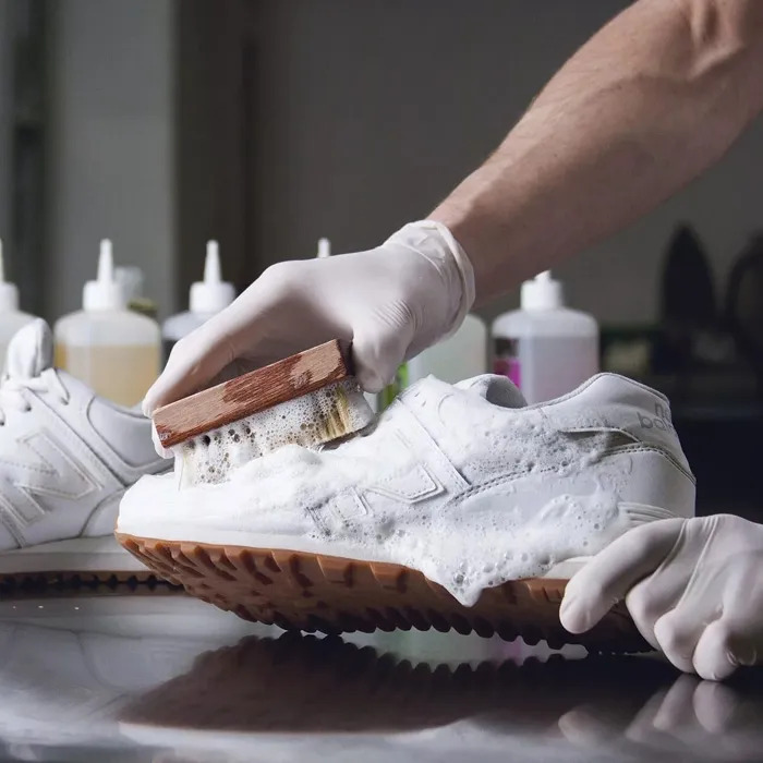 Vệ sinh giày sneaker bằng bàn chải và dung dịch
